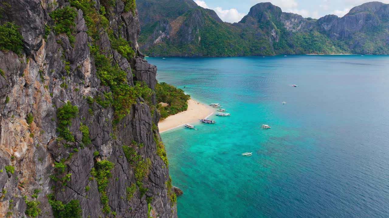 Drone che si allontana da scogliere calcaree rivelando l'Isola Elicottero, Filippine