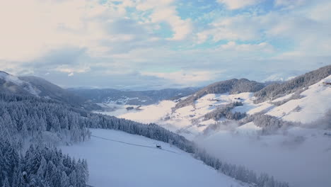 Mountain-slopes-in-snow-and-golden-sunlight,-quiet-winter-solitude,-aerial-view