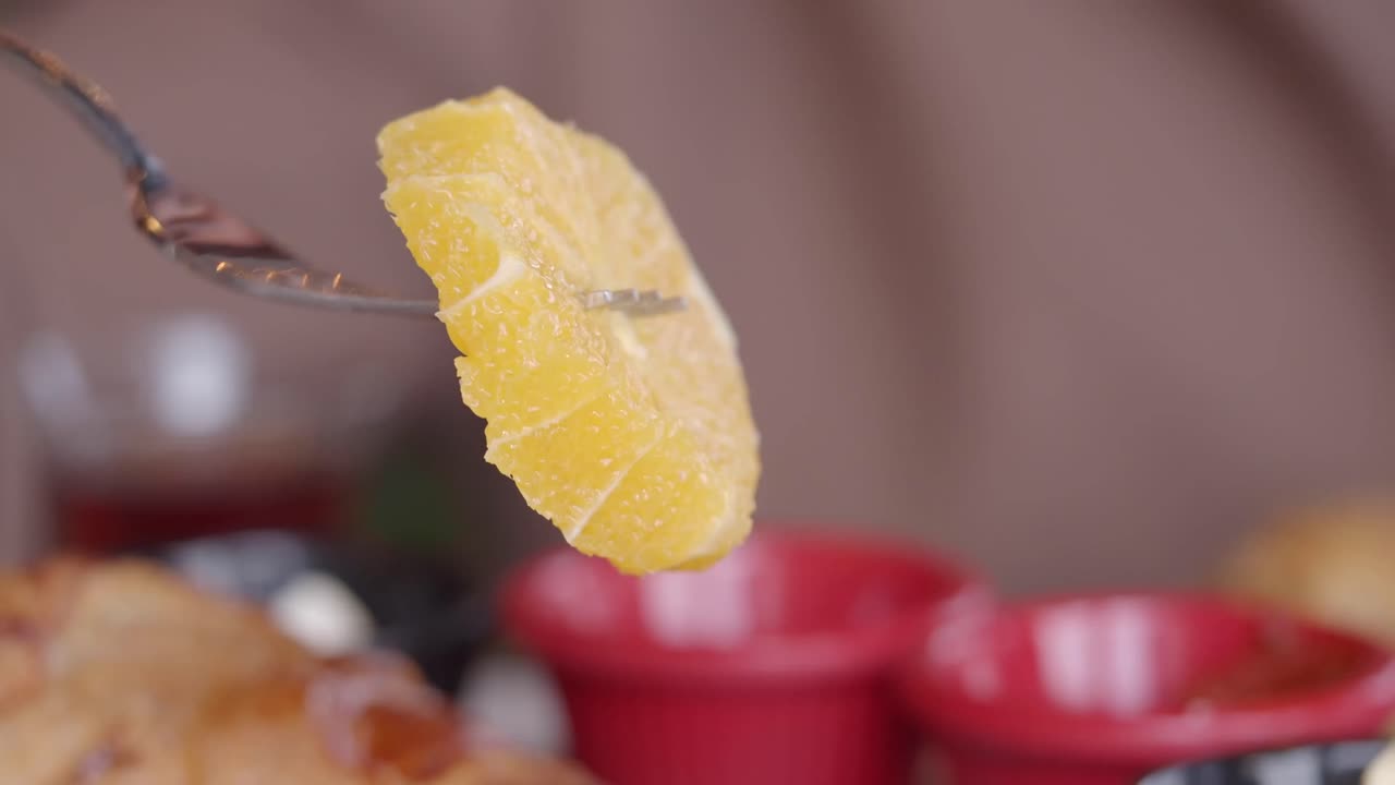 Primo piano di una fetta d'arancia fresca su una forchetta.