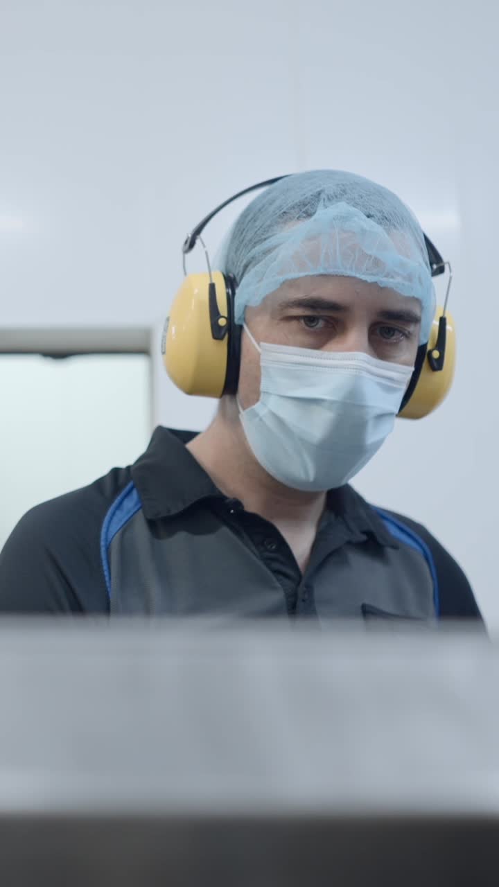 Man in protective gear working in a factory or cleanroom