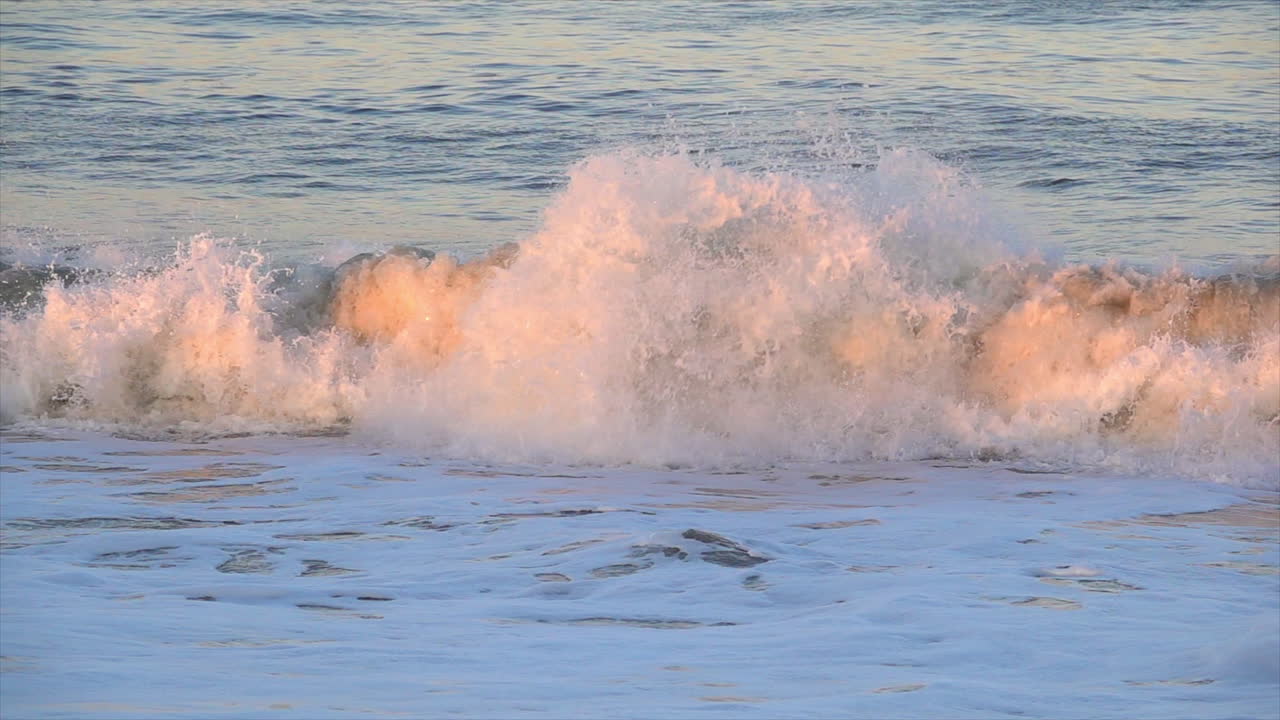 Wave breaking at sunset on the coast of Bethany Beach, Delaware. Slow motion