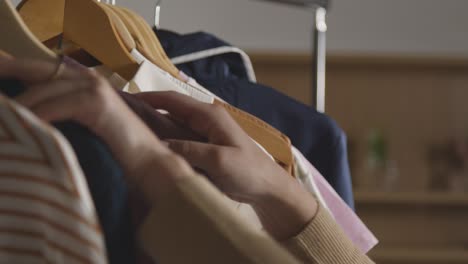 close up of woman at home choosing business suit from clothes rail for job interview 1