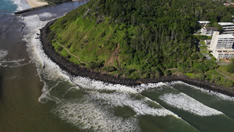 ocean waves crashing against rocky coast of burleigh head national park - burleigh heads rock pools in qld, australia