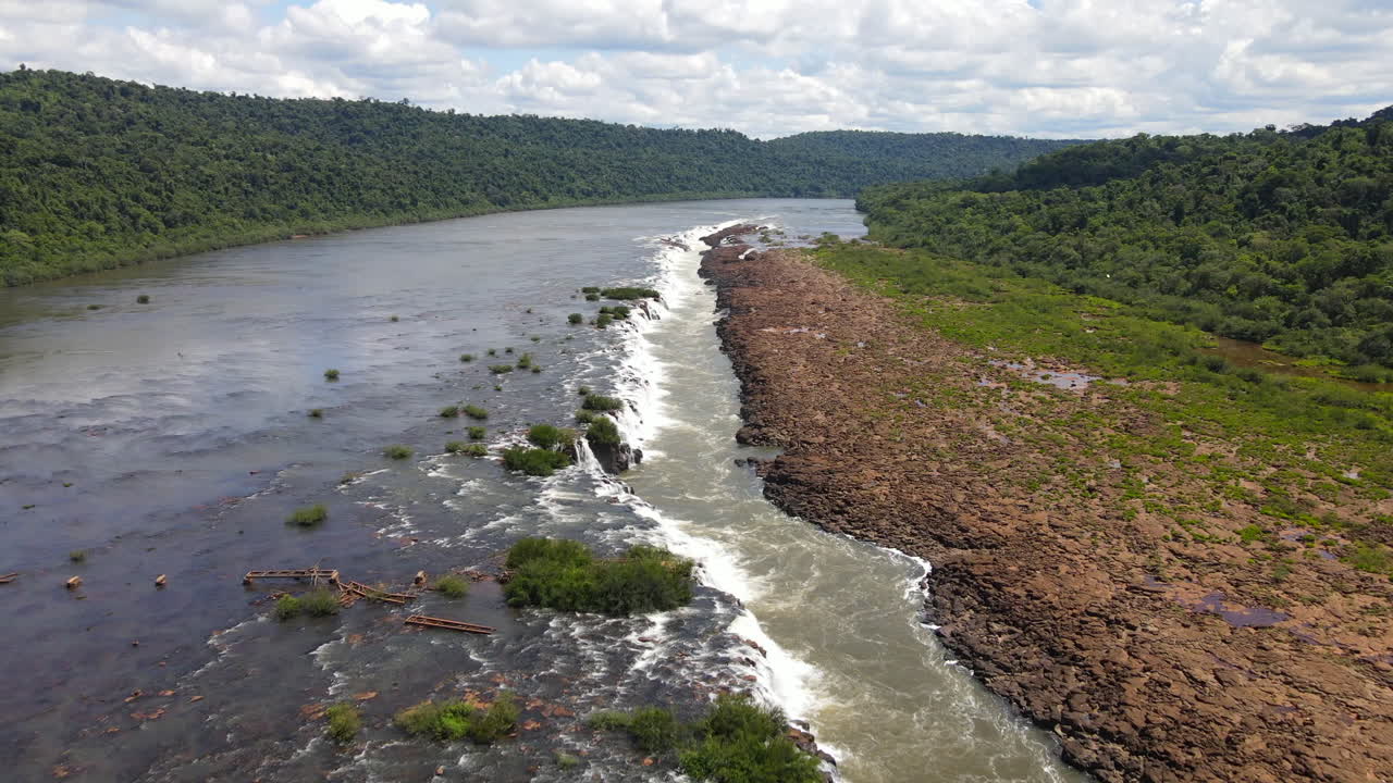 Aerial zoom in of the Saltos del Mocon&aacute; or Salto do Yucum&atilde; captured on an incredibly clear and blue day, showcasing the majestic beauty of the longitudinal waterfalls on the Argentina-Brazil border