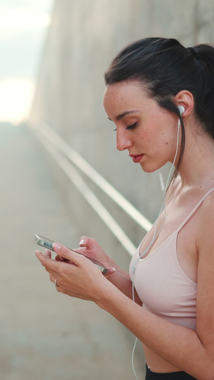 Woman using smartphone with earbuds