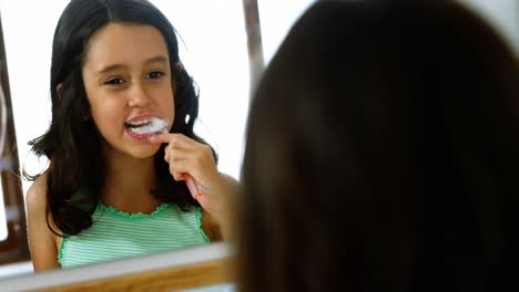 chica cepillándose los dientes en el baño