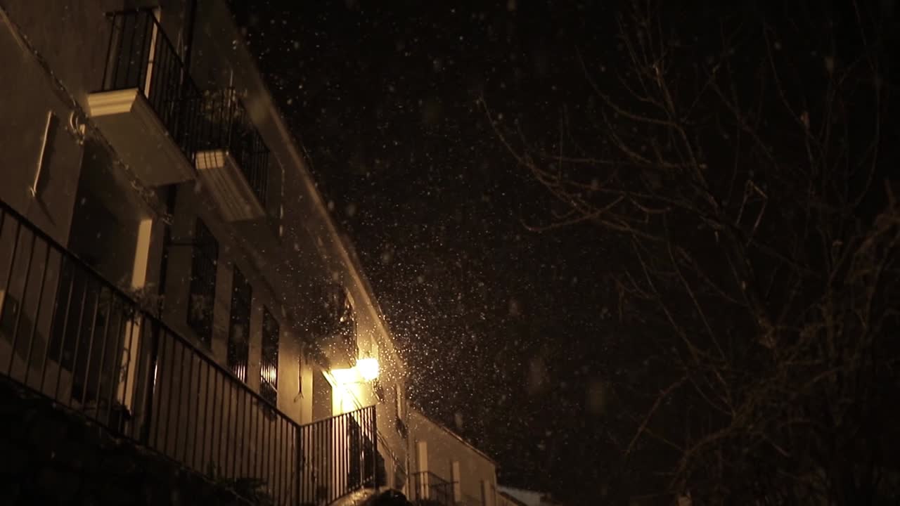 fachadas de edificios viejos con luz brillante en la nieve por la noche
