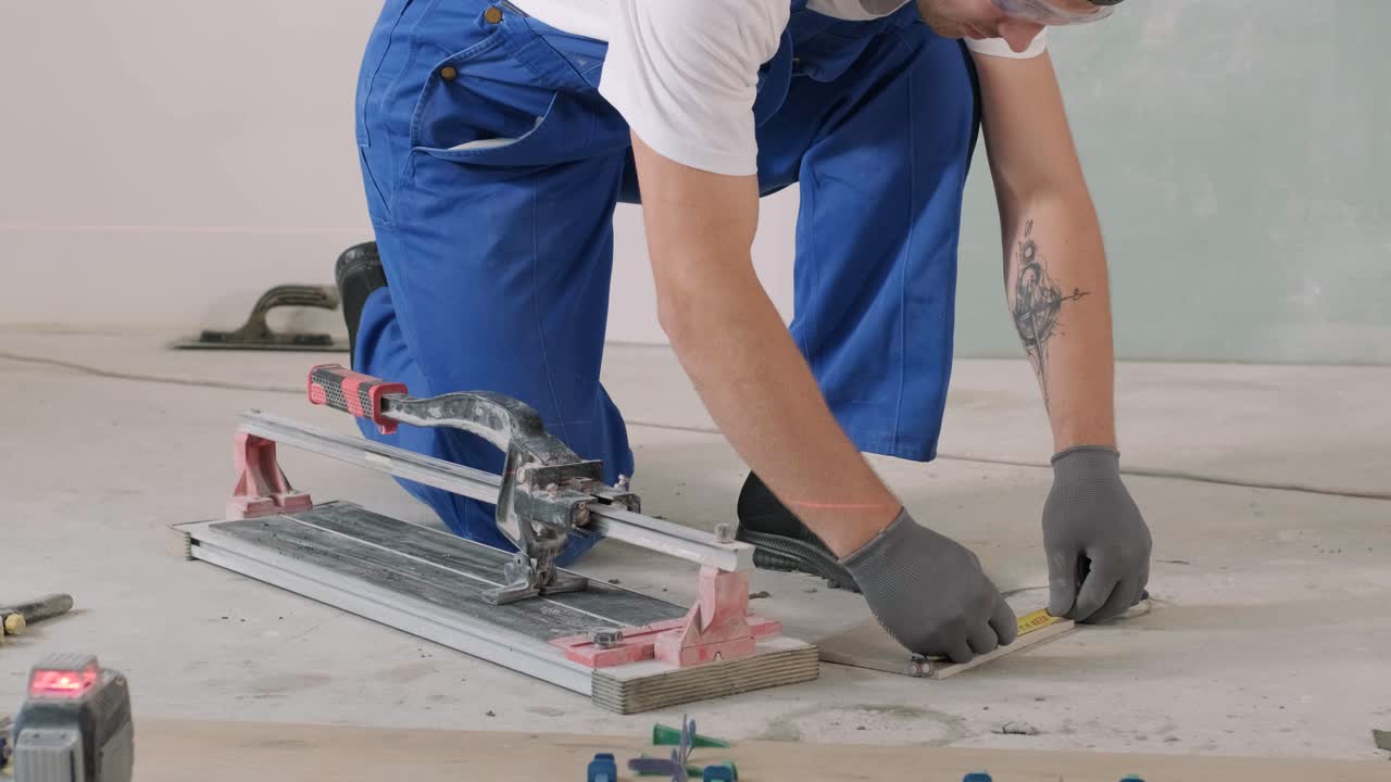 건설, 리모델링, 수리 아파트. 세라 바닥 타일 설치 - 조각을 측정하고 잘라내는. 타일 잘라. 타일 절단