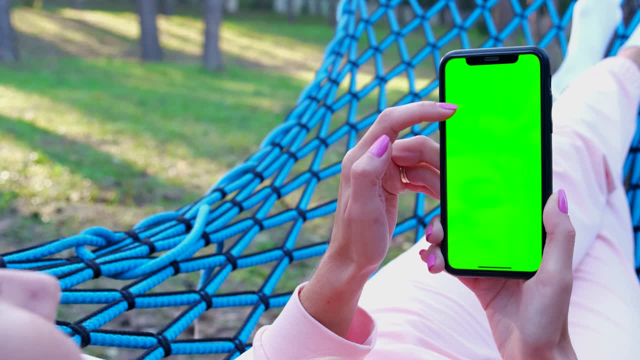 chica sosteniendo un teléfono inteligente con una pantalla de tecla de croma