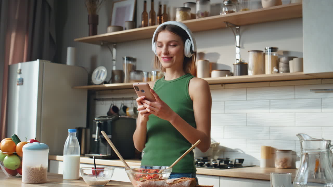 Woman Listening to Music While Preparing Food in Kitchen