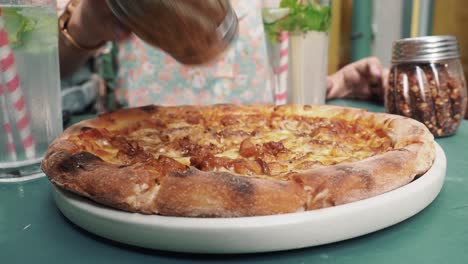 Schöne-Mädchenhände,-Die-Oregano-In-Hühnerpizza-Gießen