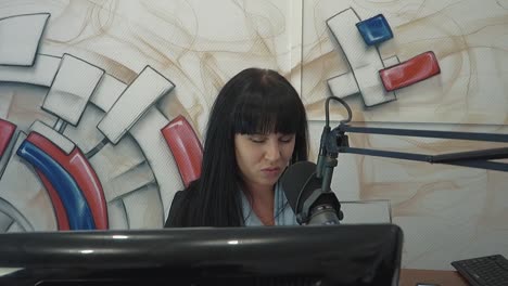 Radio-DJ-in-the-broadcast-studio-The-girl-puts-a-finger-to-her-head-representing-fatigue