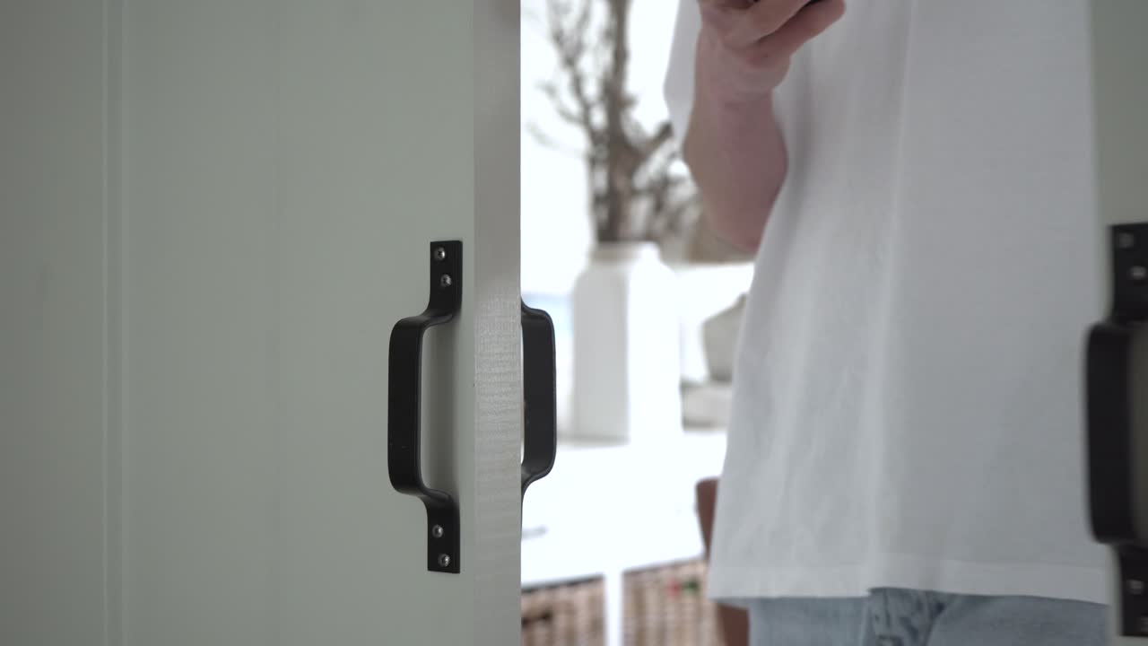 슬라이딩 문이 있는 다른 방에서 방으로 들어오는 사람