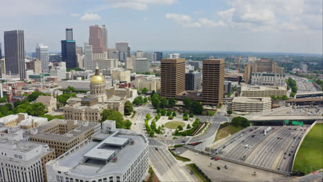 Vista-Aérea-Panorámica-Del-Tráfico-De-La-Autopista-De-Atlanta-Con-La-Oficina-Gubernamental-Del-Capitolio-Del-Estado-De-Georgia-Y-Los-Edificios-Y-Rascacielos-Del-Horizonte-Del-Centro-De-Atlanta-A-La-Vista,-Georgia,-Estados-Unidos