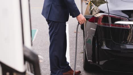 low section of caucasian man charging electric car