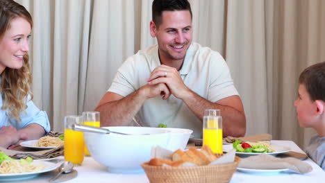 joven familia feliz charlando en la mesa de la cena