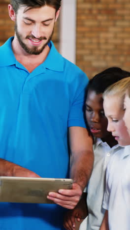 maestro de deportes y niños de la escuela usando tableta digital en la cancha de baloncesto