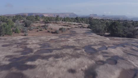 Escena-Aérea-Sobre-Charcos-De-Agua-De-Lluvia-En-Slickrock-En-El-Desierto-De-Moab---Utah