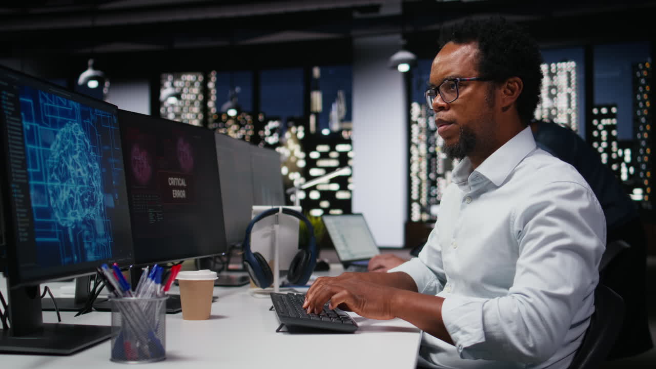 African American Programmer Working on Computer in Modern Office at Night
