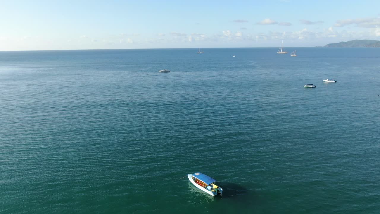vista de drones de la playa de costa rica que muestra el mar en el océano pacífico en un día soleado con algunos pequeños barcos