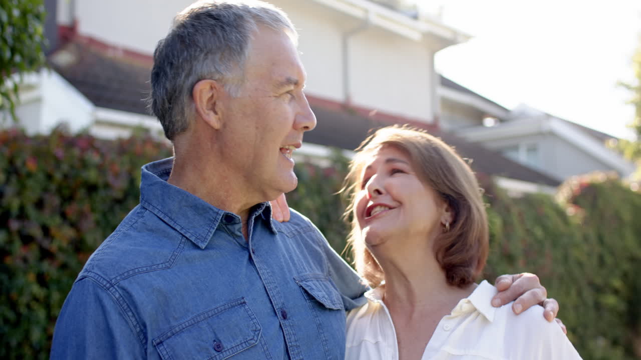 Smiling and embracing outdoors, senior couple enjoying time together