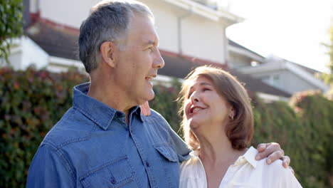 smiling and embracing outdoors, senior couple enjoying time together