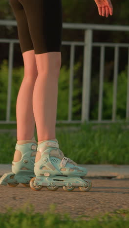 vista lateral de una persona patinando cerca de una barandilla de hierro bajo la cálida luz del sol de la noche, las patinetas proyectando sombras en el pavimento, el fondo presenta vegetación exuberante y árboles