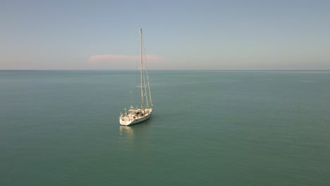 Aerial-orbit-view-of-sailing-Yacht-ocean-with-Islands-and-turquoise-ocean