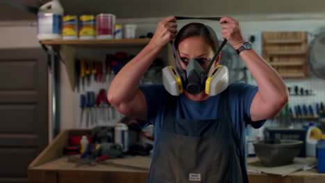 woman adjusting respirator mask in a workshop