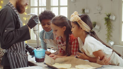 chef enseñando a los niños cómo usar la licuadora durante la clase de cocina