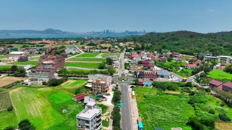 aerial flight over road with roundabout and buildings on kinmen island 金門 quemoy, during sunny day with blue sky, taiwan