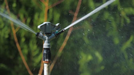 sprinkler spins in a circle and sprays water.