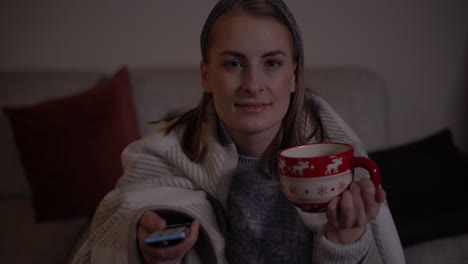 Mujer-Cubierta-Con-Una-Manta-Caliente-Viendo-La-Televisión-En-El-Salón-En-Navidad-1