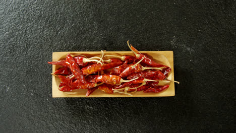 dried chili pepper in wooden tray 4k