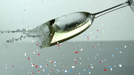 Animation-of-confetti-falling-over-champagne-glass