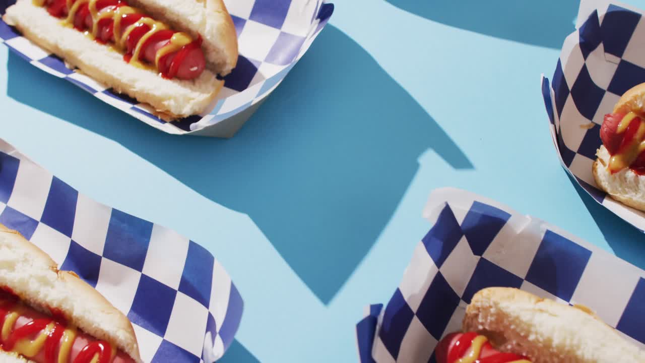 Video di hot dog con senape e ketchup su una superficie blu