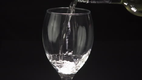 mano vertiendo un vaso de vino blanco fresco y bebiendo de él