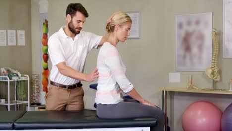 male physiotherapist giving back massage to female patient