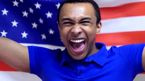 un fanático estadounidense celebra sosteniendo la bandera de los estados unidos en cámara lenta.