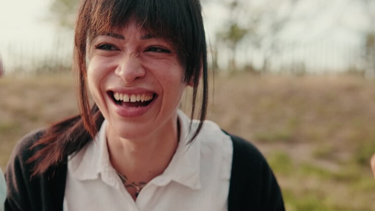 Vrienden die genieten van een picknick en lachen, focus op de vrouw