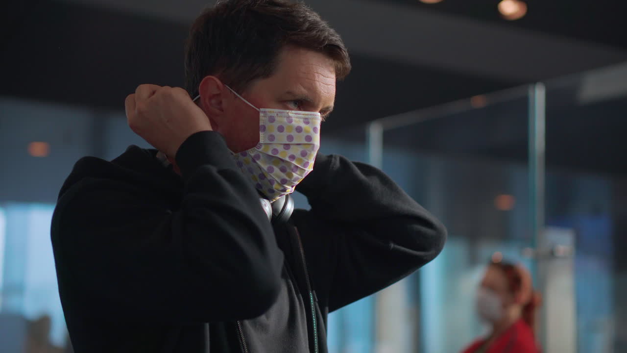 человек, надевающий маску на лицо