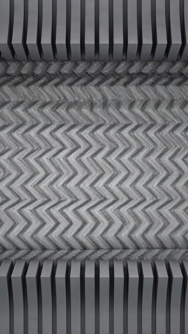 Vertical video: Engaging rollers driving central web for embossing in factory, with slats