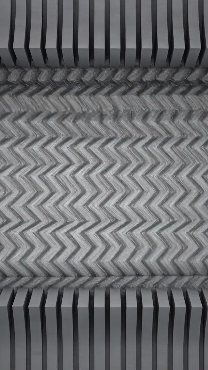 Vertical video: Engaging rollers driving central web for embossing in factory, with slats
