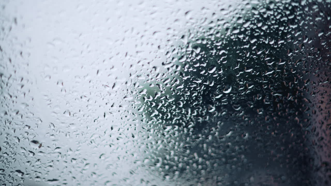 Close up of raindrops on a glass window with soft bokeh background