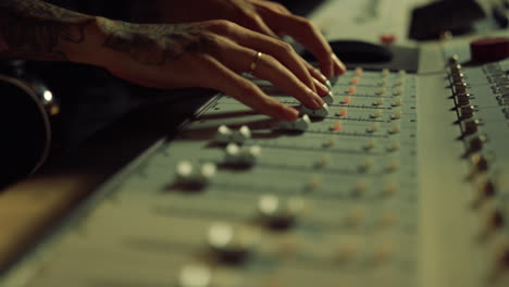 sound engineer moving sliders on control desk. man hands touching soundboard.