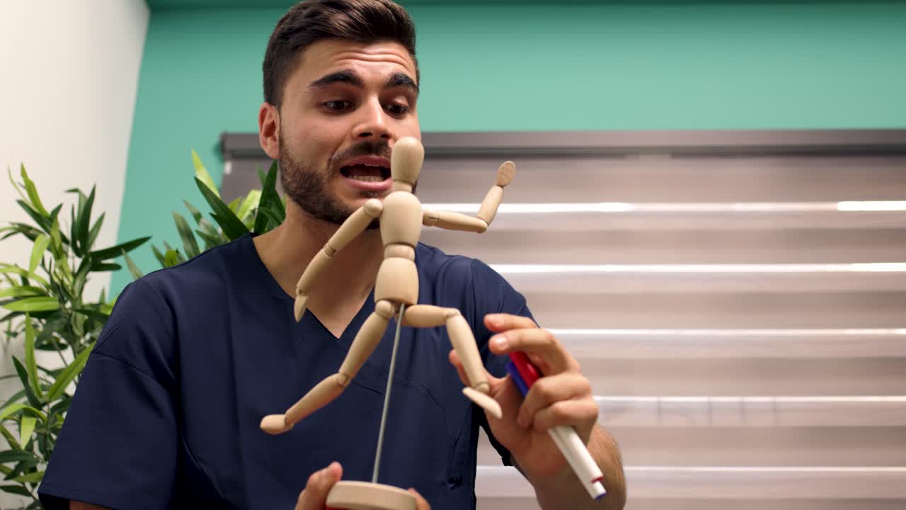 Jovem Médico Explicando Anatomia Humana com Manequim de Madeira