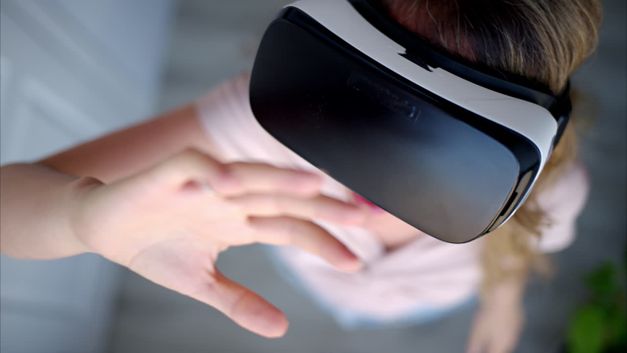 Woman with long hair wearing black VR virtual reality headeset and playing