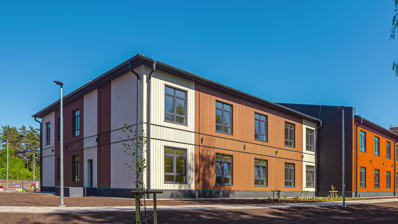 sombras de árboles moviéndose sobre una escuela en riga en un día soleado