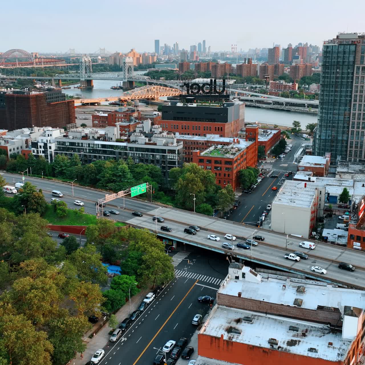 Flight above the buildings tops and busy roads. New York bridges over Hudson at backdrop