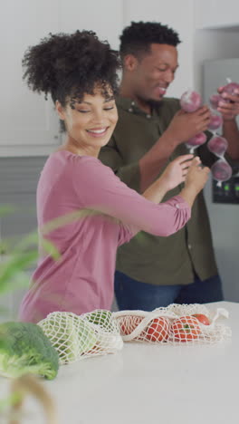video vertical de una feliz pareja afroamericana con verduras en la cocina
